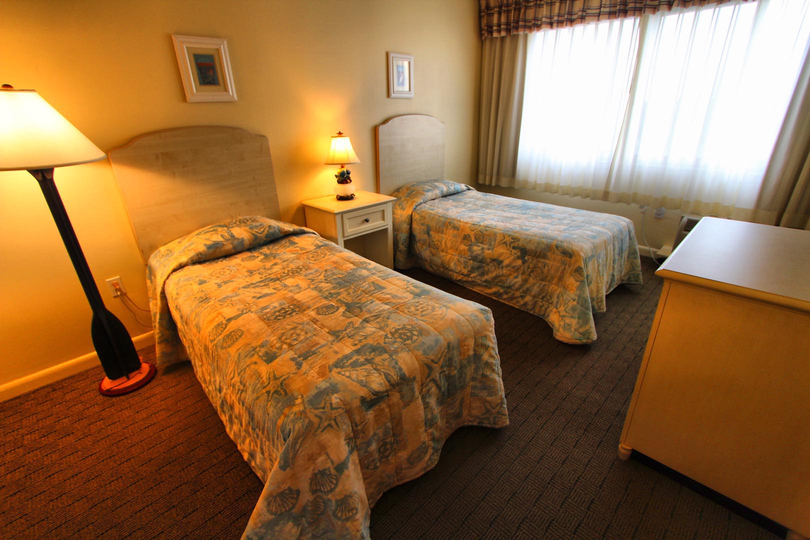 A bedroom with double beds at VRI's Brigantine Beach Club in New Jersey.